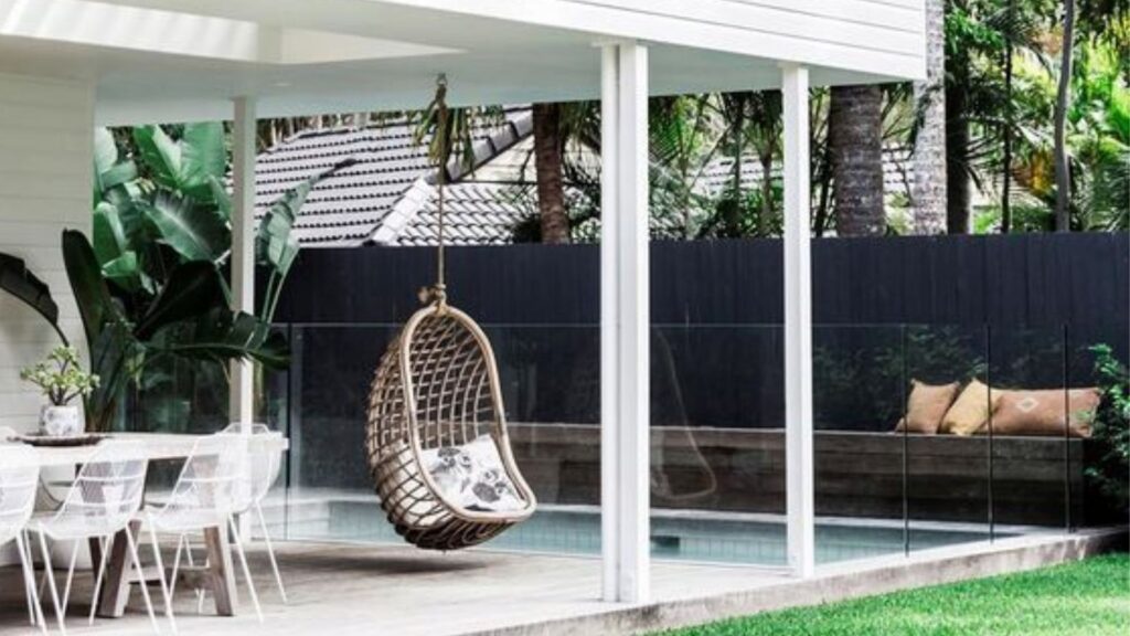 Extend your outdoor entertaining areas with built in seating along the fence by the pool, a hanging chair, and an outdoor dining area. This increases the number of functional spaces in your garden and reduces the grass and garden areas that need maintaining. 